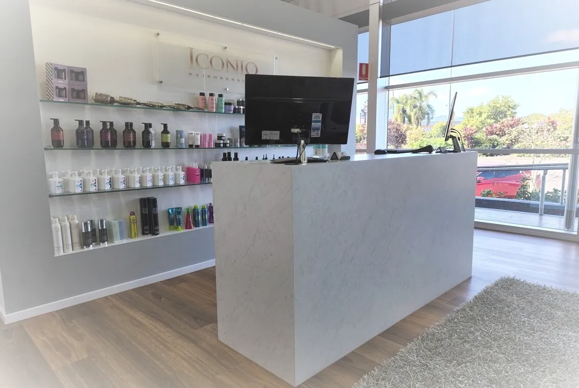 Iconiq salon front desk with product shelving and windows