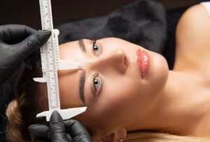 Precision eyebrow shaping and measurement, showcasing meticulous attention to detail.