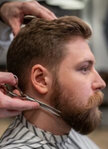 Men’s haircut and beard trimming in progress, showcasing precision grooming at Iconiq Hairdressing Cairns.