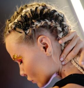 Braided hairstyle with bold black and blonde highlights, showcasing intricate design and creative hair artistry.